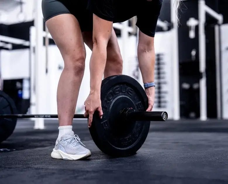 Woman adjusting barbell